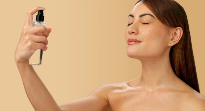 donna che si spruzza spray sul viso